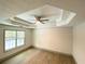 Bright bedroom features a ceiling fan, a tray ceiling, and a window at 5619 Mayfair Crossing Dr, Lithonia, GA 30038