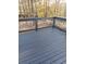 A gray wood deck with white railings overlooks a wooded backyard at 5619 Mayfair Crossing Dr, Lithonia, GA 30038