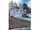 Split-level home featuring a two-car garage, gray trim, and well-maintained lawn at 5619 Mayfair Crossing Dr, Lithonia, GA 30038
