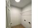 Efficient laundry room with white walls, wood-look flooring, and storage shelving at 5619 Mayfair Crossing Dr, Lithonia, GA 30038