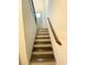 Carpetless stairs with stained wood treads and white risers lead to a landing with an exterior door at 5619 Mayfair Crossing Dr, Lithonia, GA 30038