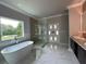 Spa-like bathroom with soaking tub, walk-in shower, and marble tile at 1534 Stargrass Dr, Grayson, GA 30017