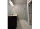 Elegant bathroom with dark vanity, marble flooring, and a frameless shower at 1534 Stargrass Dr, Grayson, GA 30017