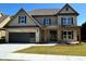 Two-story house with gray siding, brick accents, and a large front porch at 1534 Stargrass Dr, Grayson, GA 30017