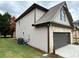 Side view of house showcasing gray siding and a dark gray garage door at 1534 Stargrass Dr, Grayson, GA 30017