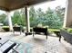 Covered patio with lounge chairs, brick floor and mature landscaping at 4140 Lanier Ridge Walk # 104, Cumming, GA 30041