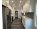 Modern kitchen with white cabinets, quartz countertops, and stainless steel appliances at 935 Pelham Nw St, Atlanta, GA 30318