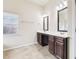 Double vanity bathroom with dark brown cabinets and tile flooring at 189 Aylesbury Blvd, Mcdonough, GA 30252