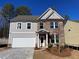 Two-story house with gray siding, brick accents, and a white garage door at 4220 Easter Lily Ave (Lot3), Buford, GA 30519