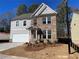 Two-story house with gray siding, brick accents, and a landscaped front yard at 4220 Easter Lily Ave (Lot3), Buford, GA 30519