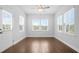 Sunny room with hardwood floors, two windows, door to exterior, and ceiling fan at 1646 Tide Mill Rd, Cumming, GA 30040
