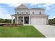Charming two-story home with a well-manicured lawn, gray siding, and attached two-car garage at 1646 Tide Mill Rd, Cumming, GA 30040