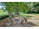 Outdoor firepit surrounded by tree stumps with forest views at 1646 Tide Mill Rd, Cumming, GA 30040