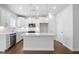 Modern white kitchen features a large island, stainless steel appliances, and pendant lighting at 1646 Tide Mill Rd, Cumming, GA 30040