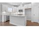 Bright, white kitchen boasts stainless appliances, subway tile backsplash, and a quartz island with pendant lighting at 1646 Tide Mill Rd, Cumming, GA 30040