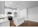 Bright, white kitchen boasts stainless appliances, and a quartz island with pendant lighting at 1646 Tide Mill Rd, Cumming, GA 30040
