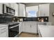 Modern kitchen features white cabinets, black tile backsplash, and stainless steel appliances at 1646 Tide Mill Rd, Cumming, GA 30040