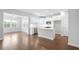 Open-concept kitchen with white cabinets, stainless steel appliances, and hardwood floors at 1646 Tide Mill Rd, Cumming, GA 30040