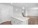 Bright, white kitchen island with quartz countertops, pendant lighting, and an open layout to the living area at 1646 Tide Mill Rd, Cumming, GA 30040