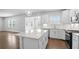 Bright, white kitchen boasts stainless appliances, and a quartz island with pendant lighting and an open layout at 1646 Tide Mill Rd, Cumming, GA 30040