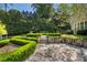 Backyard with stone paths, manicured hedges, and lush trees, seamlessly blending nature with architectural design at 3685 Paces Ferry Nw Rd, Atlanta, GA 30327