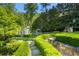 Lush backyard with manicured shrubbery, a charming playhouse, and inviting stone pathways, perfect for relaxation at 3685 Paces Ferry Nw Rd, Atlanta, GA 30327