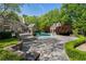 Luxury backyard featuring a sparkling pool, expansive stone patio, and lush, mature landscaping at 3685 Paces Ferry Nw Rd, Atlanta, GA 30327