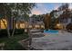 Backyard patio and swimming pool with spa and an outdoor cabana at dusk at 3685 Paces Ferry Nw Rd, Atlanta, GA 30327