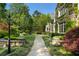 Stone mansion featuring lush landscaping, manicured hedges, and a stone walkway leading to the front door at 3685 Paces Ferry Nw Rd, Atlanta, GA 30327