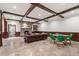 A finished basement living room has stone fireplace, wooden beams and travertine floors at 3685 Paces Ferry Nw Rd, Atlanta, GA 30327