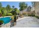 Spacious stone patio overlooks a beautiful in-ground pool and meticulously landscaped backyard at 3685 Paces Ferry Nw Rd, Atlanta, GA 30327