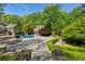 In-ground pool and spa, featuring a stone surround, and mature landscaping, create a private outdoor living space at 3685 Paces Ferry Nw Rd, Atlanta, GA 30327