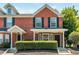 Brick front of charming townhome with landscaping and double door entry at 211 Morris Ln, Woodstock, GA 30188