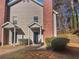 Tan two-story townhome with brick chimney and small front yard at 5431 Village Green Sq # 1018, Norcross, GA 30093