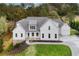 Two story white farmhouse with gray roof, stone accents, and detached garage at 113 Creekview Ln, Canton, GA 30115