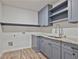 Laundry room with gray cabinets, granite countertop, and shelving at 113 Creekview Ln, Canton, GA 30115