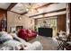 Living room featuring brick wall, wood beams, and large TV at 3059 Sorrento Sw Cir, Atlanta, GA 30331