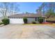 Exterior view of the home featuring a garage, driveway, and manicured landscaping at 2065 Arbor Forest Sw Dr, Marietta, GA 30064