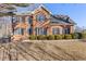 Brick two-story house with a landscaped lawn and mature trees at 5480 Landseer Way, Cumming, GA 30040