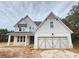 Two-story farmhouse features a large garage and front porch at 5250 Ridge Farms Dr, Cumming, GA 30041