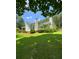 Side view of a white house with green roof, lawn, and trees at 3639 Holly Springs Rd, Rockmart, GA 30153