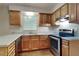 Galley kitchen with light wood cabinets and stainless steel appliances at 620 Sheringham Ct, Roswell, GA 30076