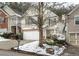 Two-story townhome with a white garage door and snow-covered landscaping at 646 Lakes Cir, Lithonia, GA 30058