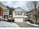 Two-story townhome with a white garage door and snow-covered landscaping at 646 Lakes Cir, Lithonia, GA 30058