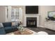 Cozy living room featuring a fireplace with black tile surround, a sofa, and a large window at 646 Lakes Cir, Lithonia, GA 30058