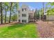 Spacious backyard featuring a deck, lush green lawn, and mature trees at 135 Cedarwood Ln, Roswell, GA 30075