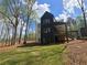 Beautiful backyard view showcasing a spacious lawn, deck, and wooded area at 135 Cedarwood Ln, Roswell, GA 30075
