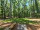 View of grassy clearing, trees, and mulched areas from backyard at 135 Cedarwood Ln, Roswell, GA 30075
