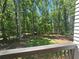 Wooded backyard view from the deck, featuring lush trees and natural surroundings at 135 Cedarwood Ln, Roswell, GA 30075