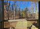 Backyard view from the covered porch featuring lush green grass and mature trees at 135 Cedarwood Ln, Roswell, GA 30075